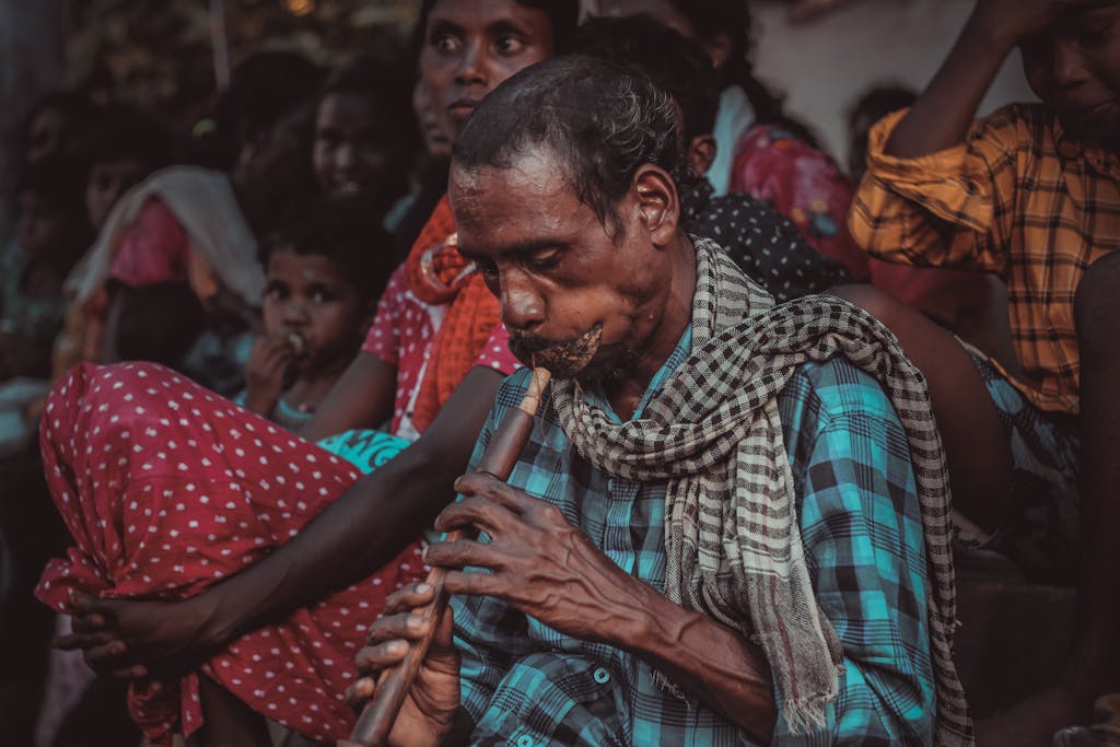 Indian musician playing a bansuri flute during a cultural gathering, showcasing traditional attire.